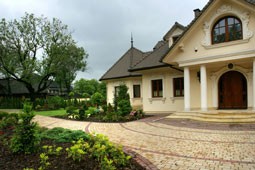 Okrągłe kształty na nawierzchni w strefach wejściowych domu dają efekt swojski i rustykalny. Kostka Krakowska (pastello i kasztanowy) Libet Decco