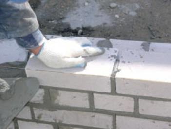 Fot. Lafarge. Do nakładania zaprawy służy kielnia, którą zbiera się także nadmiar zaprawy powstały po dociśnięciu elementów murowanych do siebie.